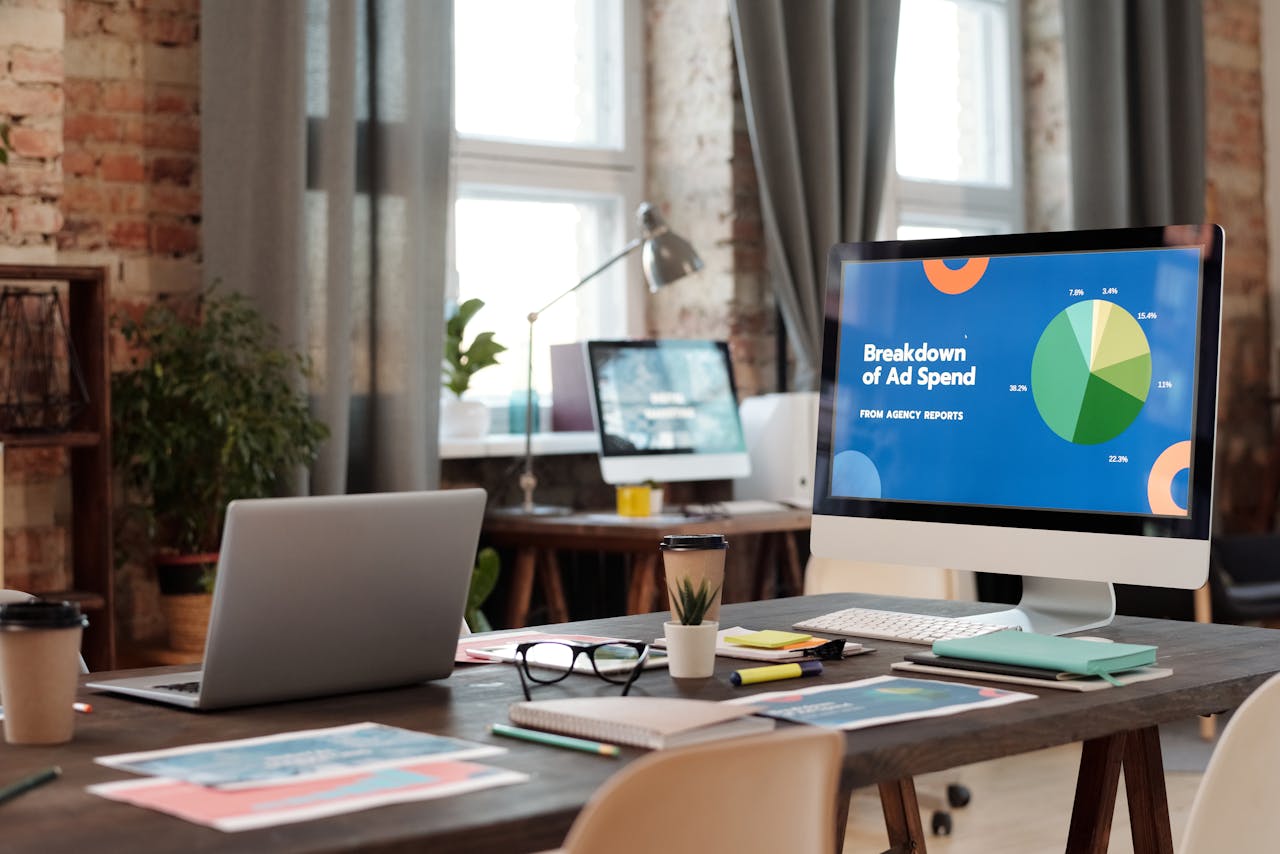 about-us A modern office workspace featuring computers, charts, and office supplies for a productive environment.